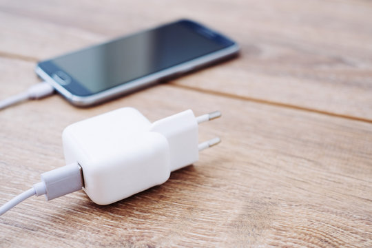 Mobile Phone And Battery Charger On A Office Desk