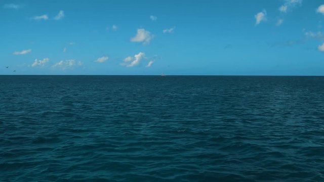 4k, uhd. A Wake From a Ship at Sea with Blue Ocean Water, a Horizon, Blue Sky and Clouds. Teal and orange style stabilizing camera. quite waves. Cruise travel.