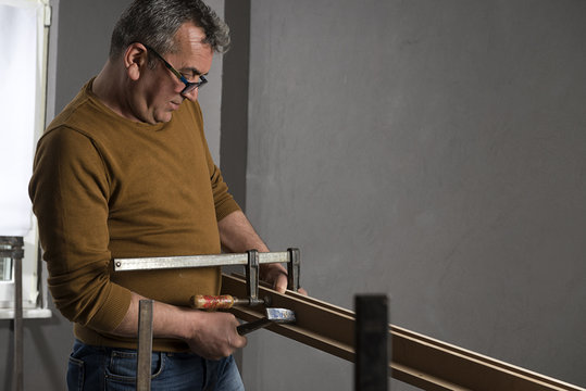Carpenter Using Bar Clamp