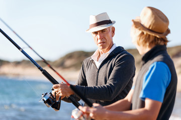 Senior man fishing with his grandson