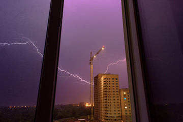 lightning on a building site, a thunderstorm view from the window