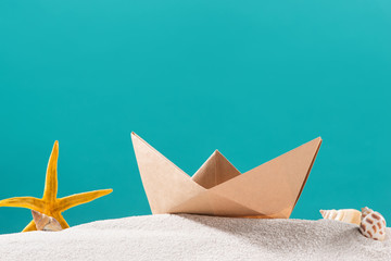 Summer traveling concept. Origami paper boats over blue background.