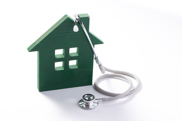 Concept of family medicine. House with stethoscope isolated on white background.