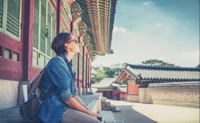 Foto op Plexiglas Vrouwenreiziger tegen de achtergrond van historische pagodegebouwen in Seoel. Welkom in Zuid-Korea © olezzo
