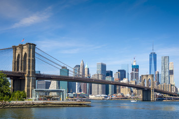 Scenic view of Brooklyn Bridge and the Lower Manhattan skyline on a bright day on the East River in...