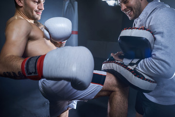 Two athletes training kicks in the gym