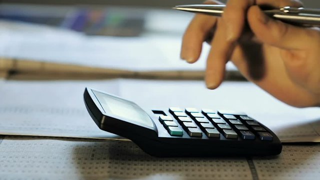 Accountant Counts the Balance in the Office on a Calculator