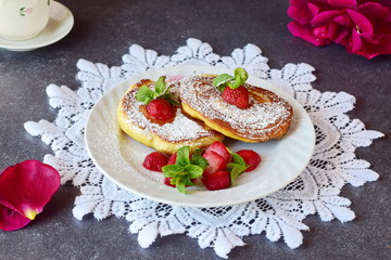 Pancakes with strawberry inside in a white plate on a white lace textile. Healthy breakfast. Healthy eating concept