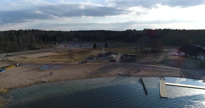 Oittaa, Cinema 4k sideway aerial view of Oittaa beach, at bodom lake, on a sunny spring day, in Espoo, Finland