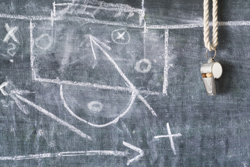 whistle of a soccer or football referee on black board with tactical diagram