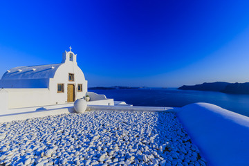 Picturesque view of Old Town of Oia on the island Santorini, white houses, windmills and church...