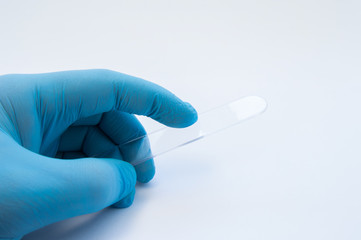  Doctor holds in hand transparent spatula to check the throat and mouth (oral cavity). Preparation for examination of patient to detect diseases in otorhinolaryngology (ENT), dentistry, pediatrics