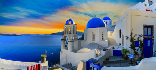 Malerische Aussicht auf die Altstadt von Oia auf der Insel Santorini, weiße Häuser, Windmühlen und Kirche mit blauen Kuppeln, Griechenland