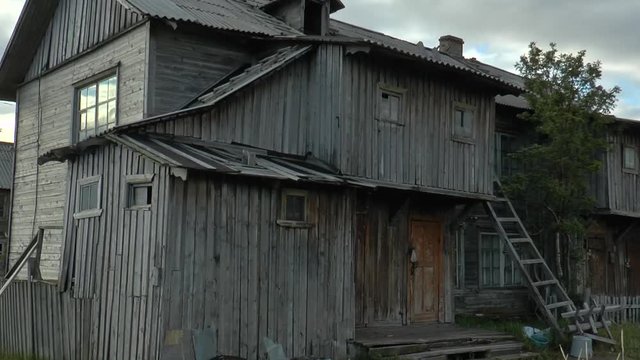TERIBERKA, RUSSIA - June 11, 2016. Dilapidated wooden houses 

in the old fishing village. Summer cloudy day.