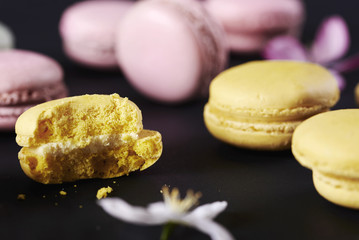 Bitten macaroon among colorful snacks