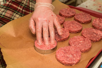 Hands kooking burger cutlets close up
