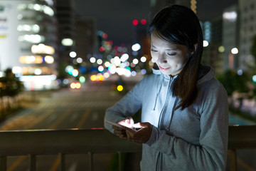 Woman looking on mobile phone at night