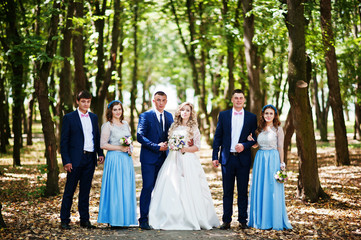 Wedding couple with bridesmaids on blue dresses and best mans having fun at wedding day.