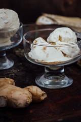 White ginger ice cream on transparent glass on black surface.