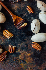 Pecan nut and wooden spoon on rustic table.