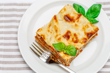 Portion of tasty lasagna isolated on white