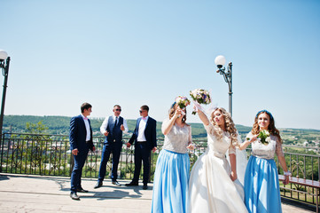 Wedding couple with bridesmaids on blue dresses and best mans having fun at wedding day.