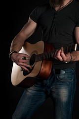 Fototapeta na wymiar Playing guitar. Acoustic guitar in the hands of the guitarist. Vertical frame