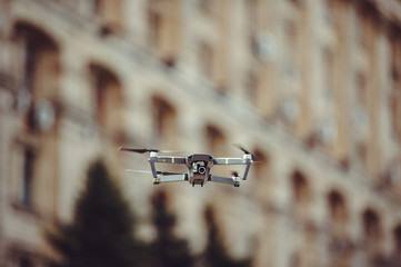 drone quadcopter in flight against the background of the city skyline