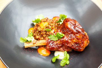 Roast leg of pig or lamb with lentils on a plate.