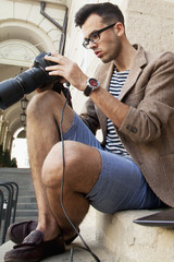 Young photographer viewing his photos on the back of the camera LCD display