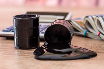 black barrel with oil lies on dollar banknotes with calculator on desk. Sale of oil. Oil