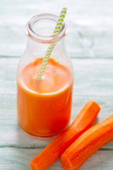 carrot juice on turquoise wooden background