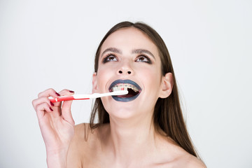 Obraz na płótnie Canvas girl with teeth braces and brush, has fashionable makeup