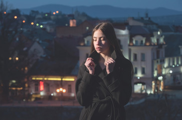 night city with girl, brunette young model in black coat