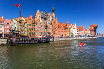 Obraz premium Pirate ship and historic port crane at Motlawa river in Gdansk, Poland