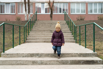 Little girl staying on the stairs