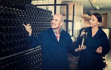man and women winemakers with wine bottle.