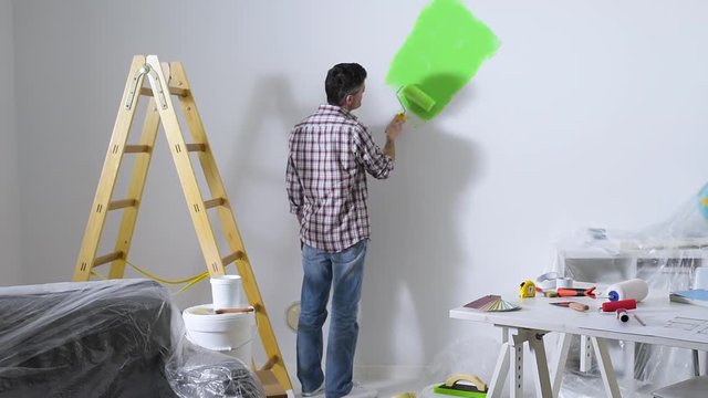 Man painting interior walls at home