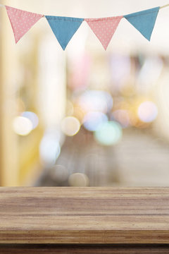 Empty wood table over colorful party flags and blur bokeh background, new year, christmas, festival background, banner