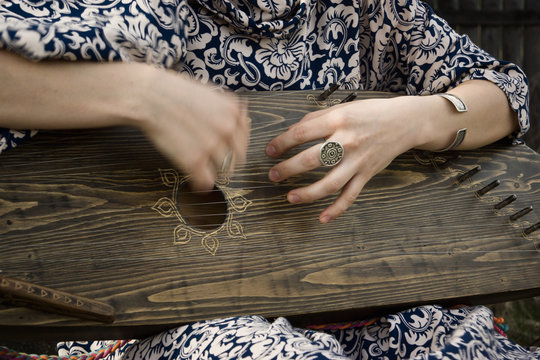 Gusli folk musical instrument in woman hands