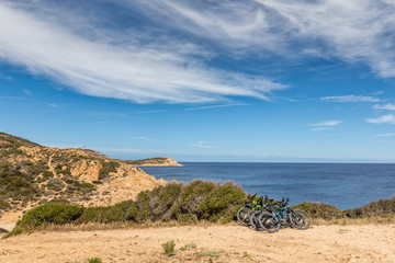 Fototapeta na wymiar Six bicycles resting on bush on coastal path in Corsica