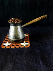 Coffee beans in a cezve on a black background