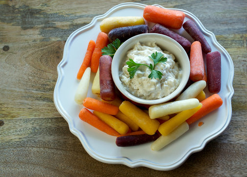 Above (top) View On Plate Of Baby Rainbow Carrots And Onion Dip In White Plate On Wooden Background, With Copyspace - Healthy Eating Concept