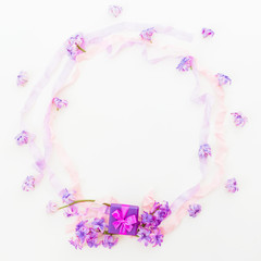 Fototapeta na wymiar Purple frame of pink hyacinth flowers and tapes on white background. Flat lay, top view. Ring box