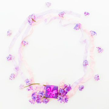 Purple frame of pink hyacinth flowers and tapes on white background. Flat lay, top view.
Ring box