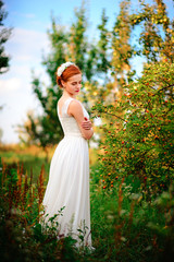 Fototapeta na wymiar Young beautiful blonde woman in blooming garden. Bride.