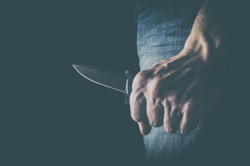 The man with a knife in a hand. Concept of crime and violence.