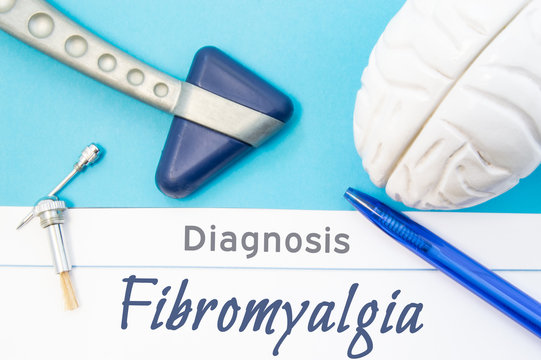 Neurological diagnosis of Fibromyalgia. Neurological hammer, human brain figure, tools for sensitivity testing are on table next to title of text diagnosis of Fibromyalgia in  workplace of neurologist