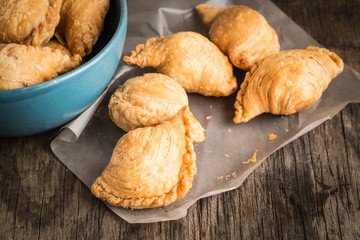Curry puff on paper on old wooden table