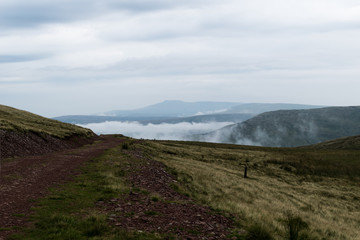 Fototapeta na wymiar Track through mountains in clouds